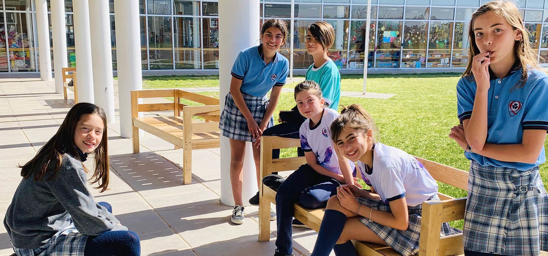Alumnas de secundaria conversando en los bancos de la galería del colegio